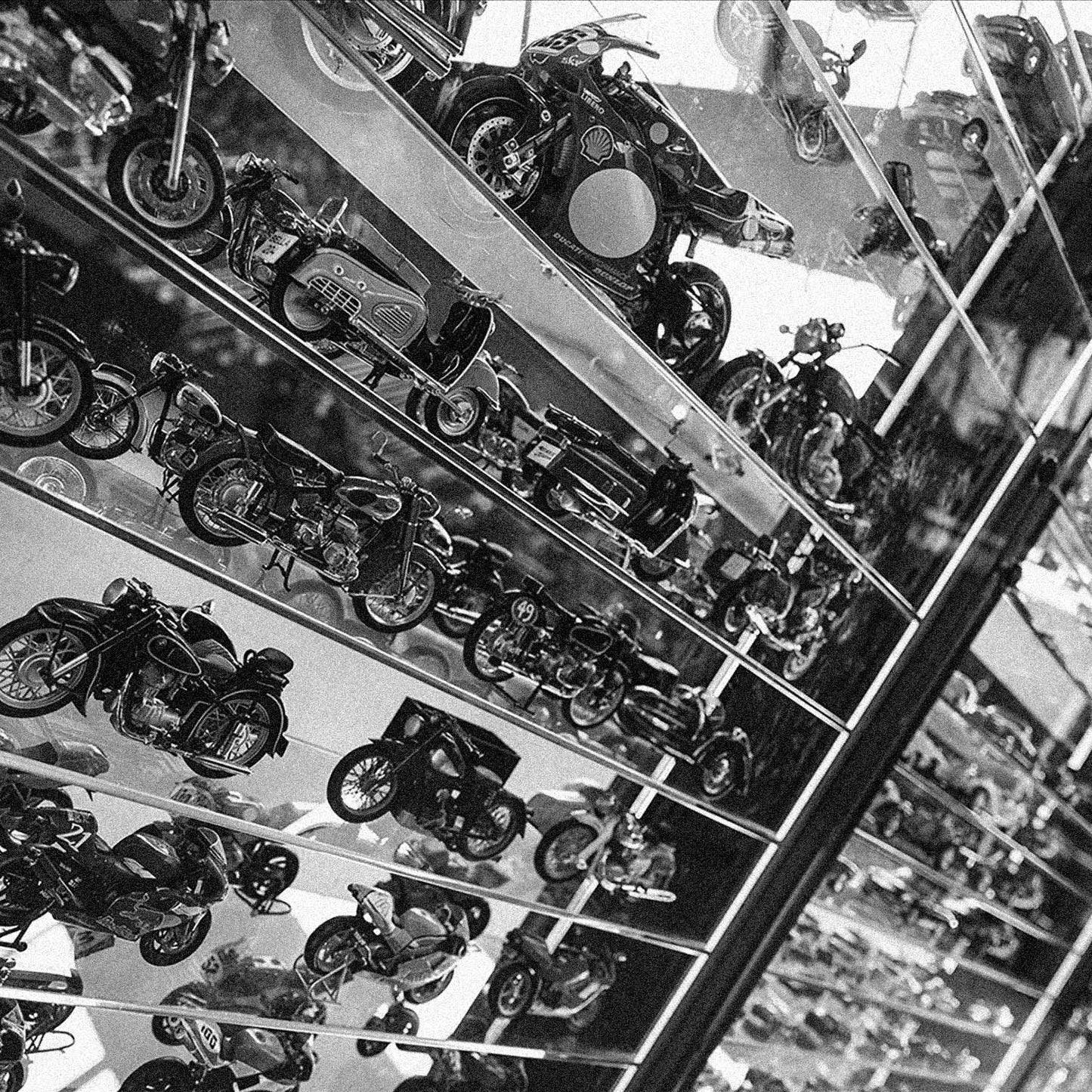 Små modelmotorcykler opstillet på glashylder